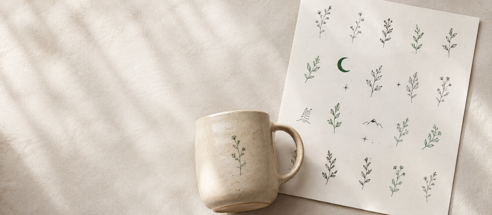 Ein A4-Bogen mit feinen Motiven neben einer fertig gebrannten Tasse